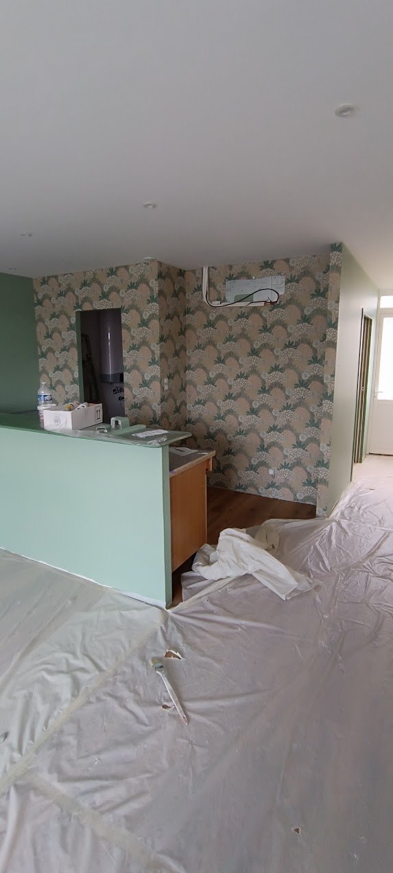 Pose de papier peint décoratif dans une pièce protégée